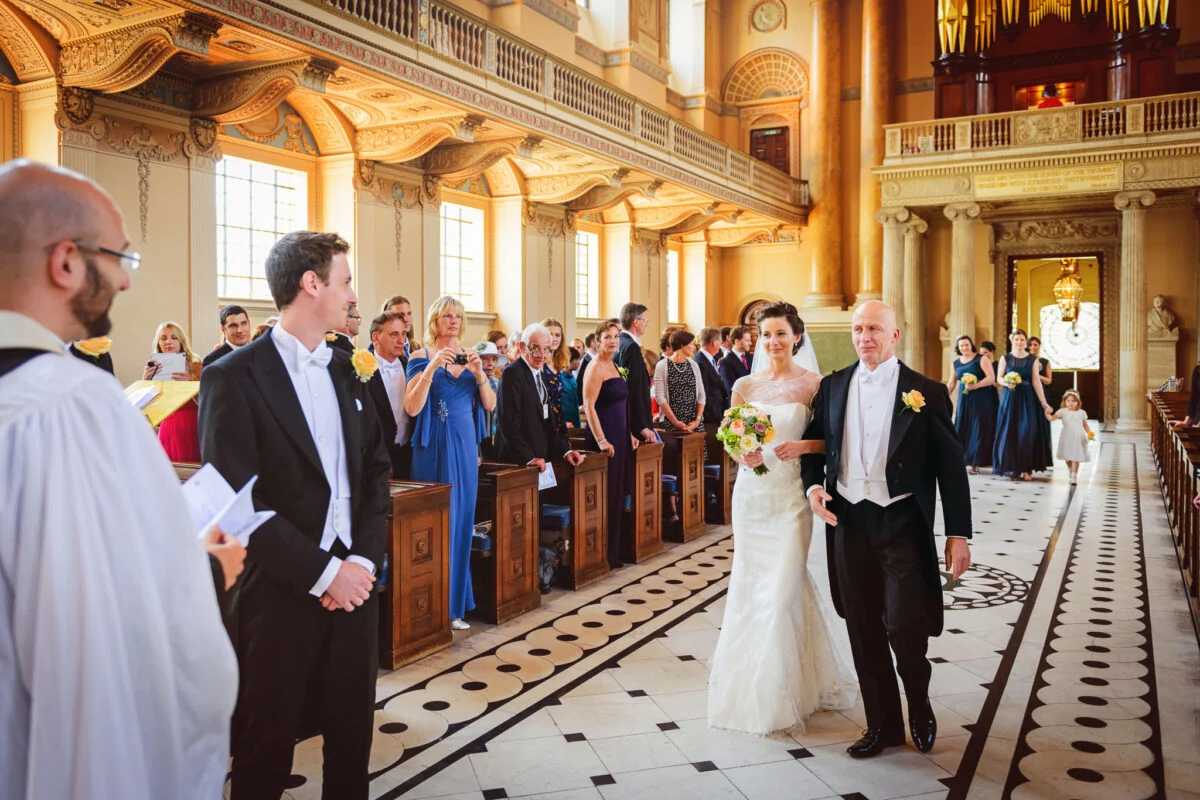 A bride and groom walking down the aisle in a church.