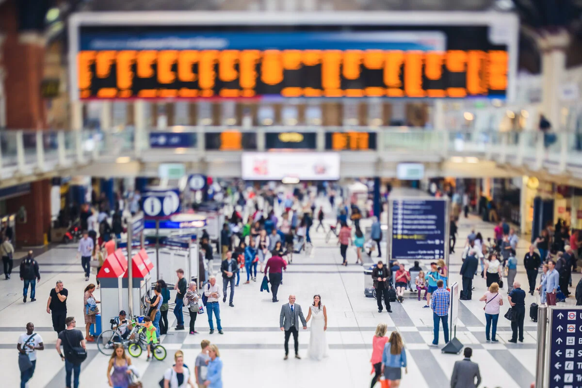 A blurry image of people walking in a train station.