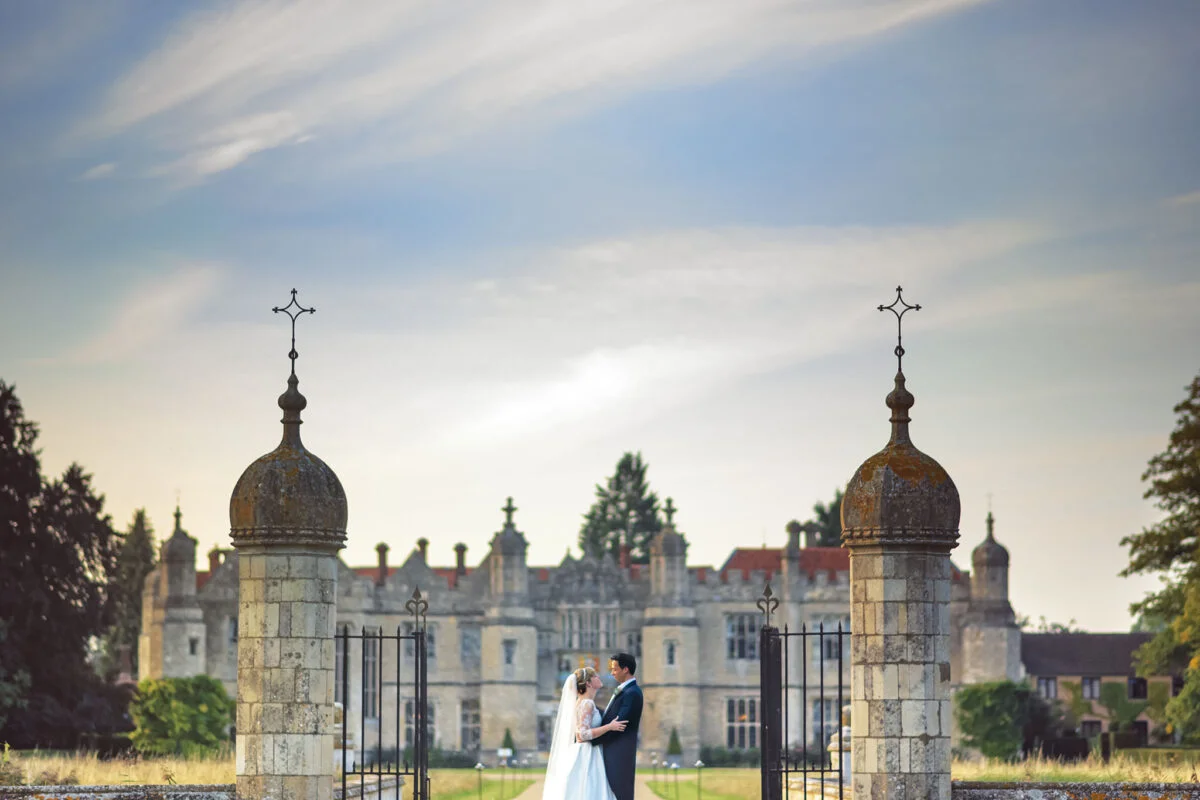 A bride and groom standing in front of a castle.
