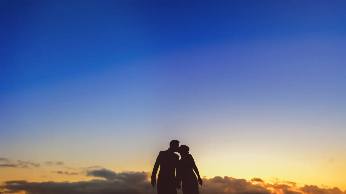 A silhouette of a couple on a beach at sunset.