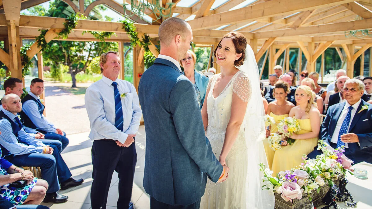A bride and groom exchange vows in an outdoor ceremony.