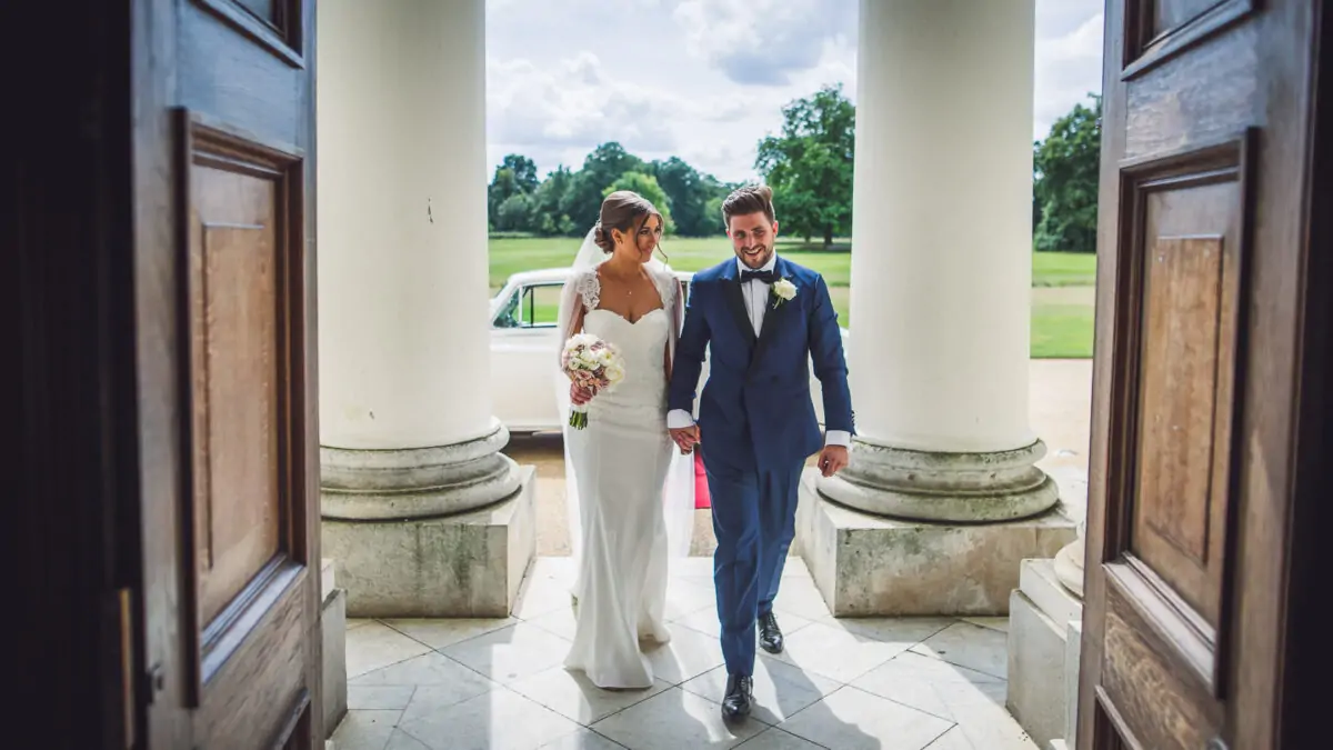 A bride and groom walking through a doorway.