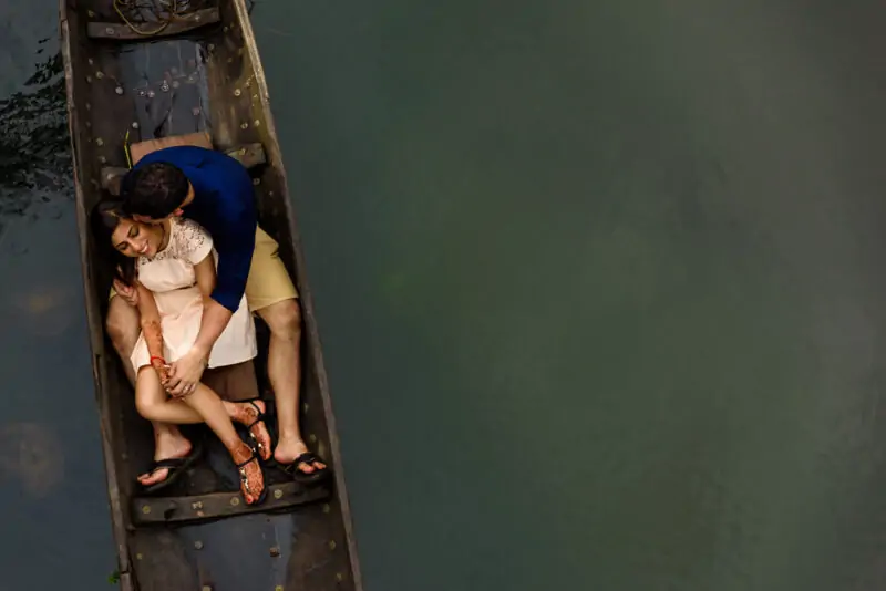 A couple sitting in a boat on a river.