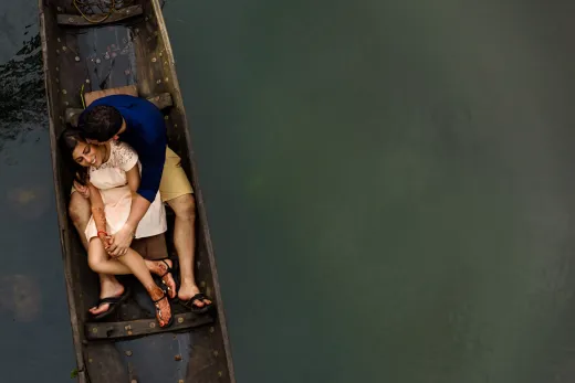 A couple sitting in a boat on a river.