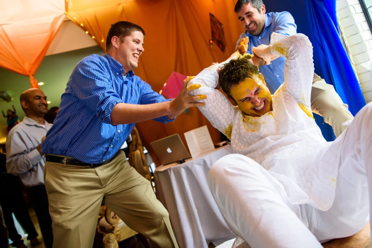 A group of men playing henna at a wedding.