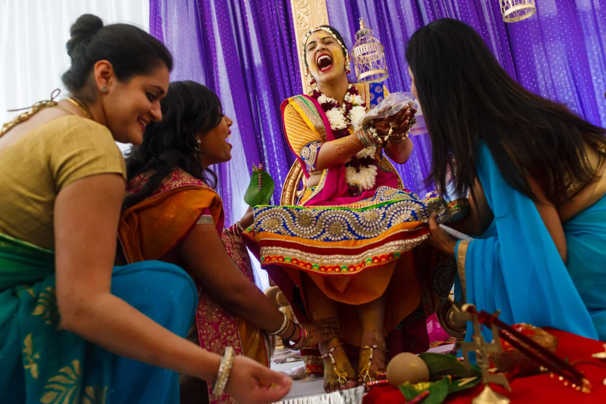 A group of indian brides laughing during their wedding ceremony.