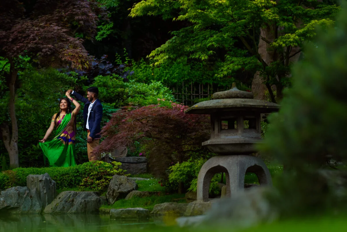 A couple in a garden with a lantern in the background.