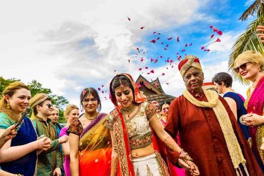 A group of indian brides and grooms posing for a photo.