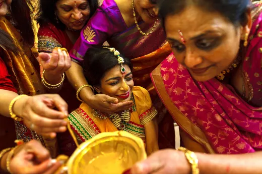 A woman is pouring gold into a bowl.