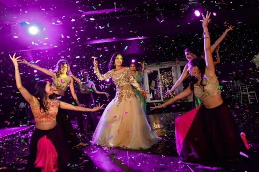 A group of women dancing with confetti at a wedding.