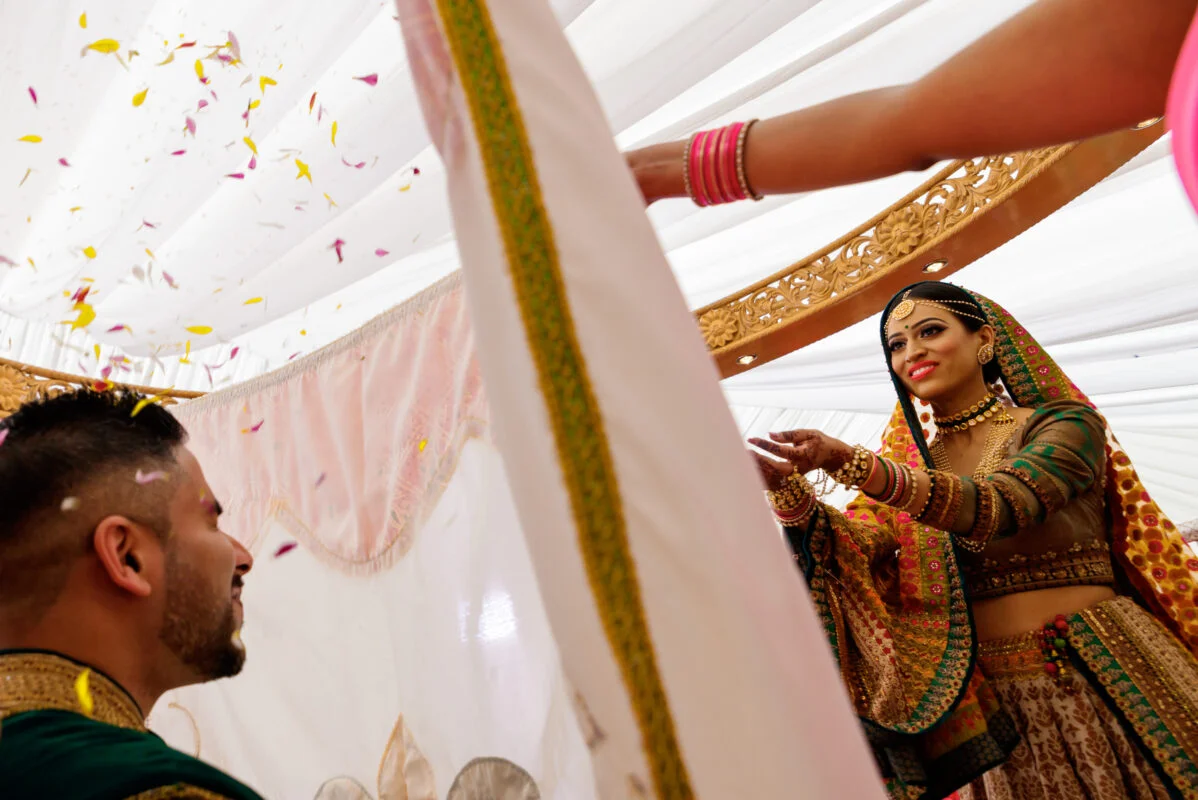 A bride and groom putting confetti on each other.