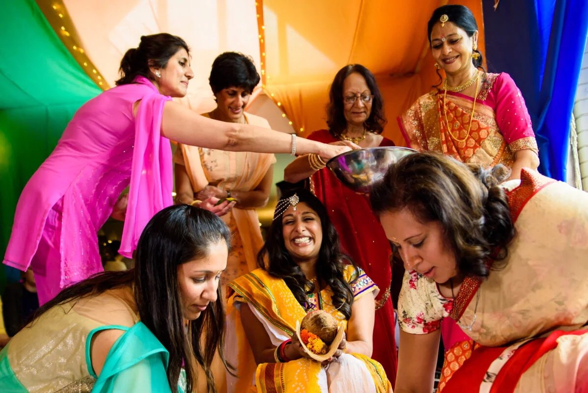A group of women in colorful saris preparing for a wedding.