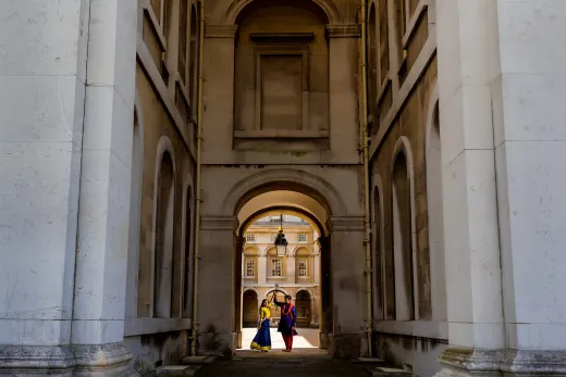 A couple walking through an archway in a building.