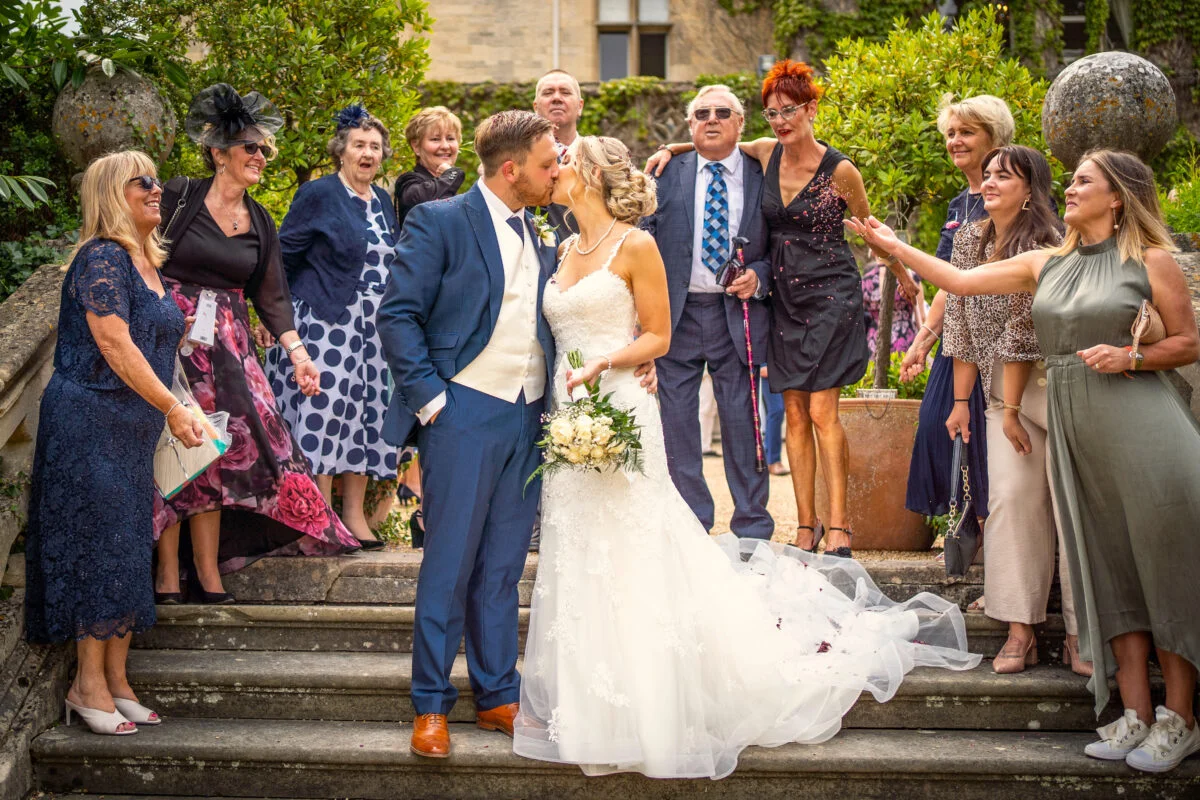 A bride and groom with their wedding party on the steps.