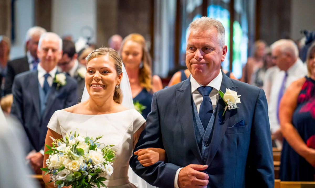 A bride walking down the aisle with her father.