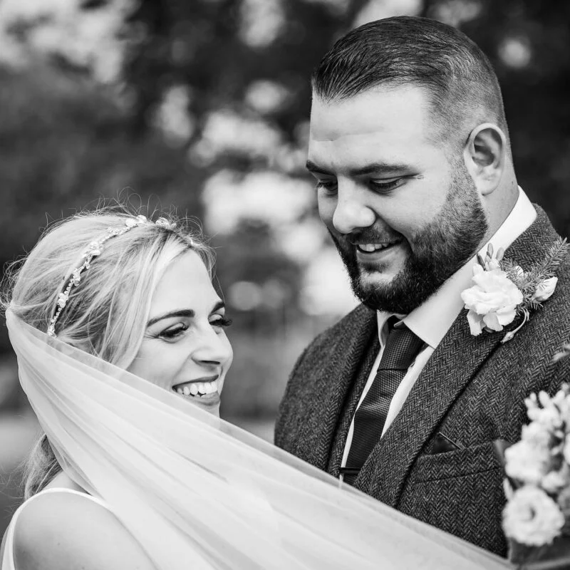 A black and white photo of a bride and groom smiling.