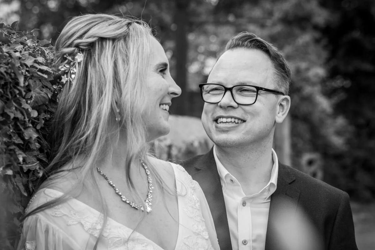 A black and white photo of a bride and groom smiling.