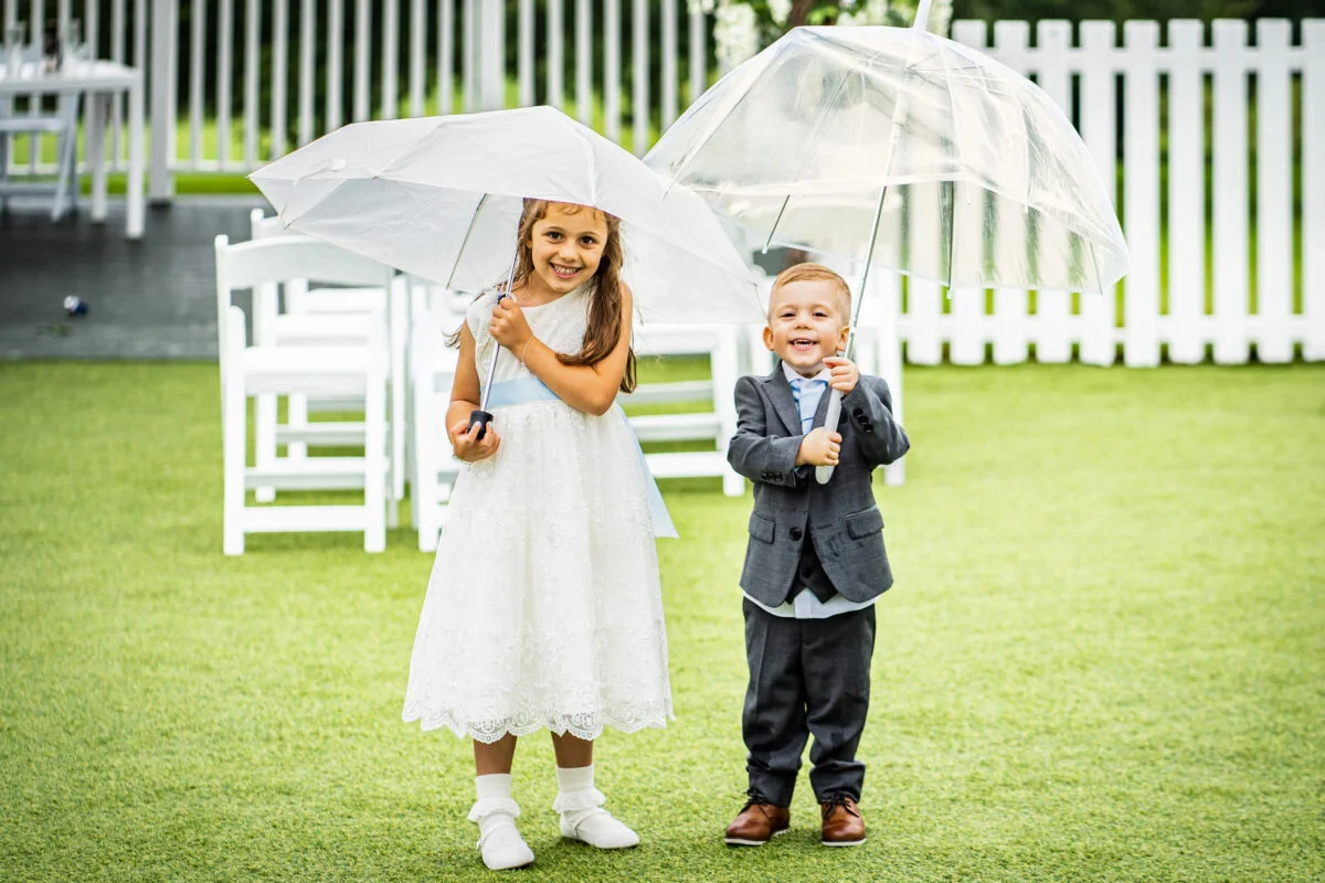 Best wedding photographer capturing a boy and a girl holding umbrellas in Bristol