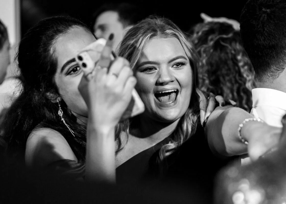 Two girls taking a selfie at a party.