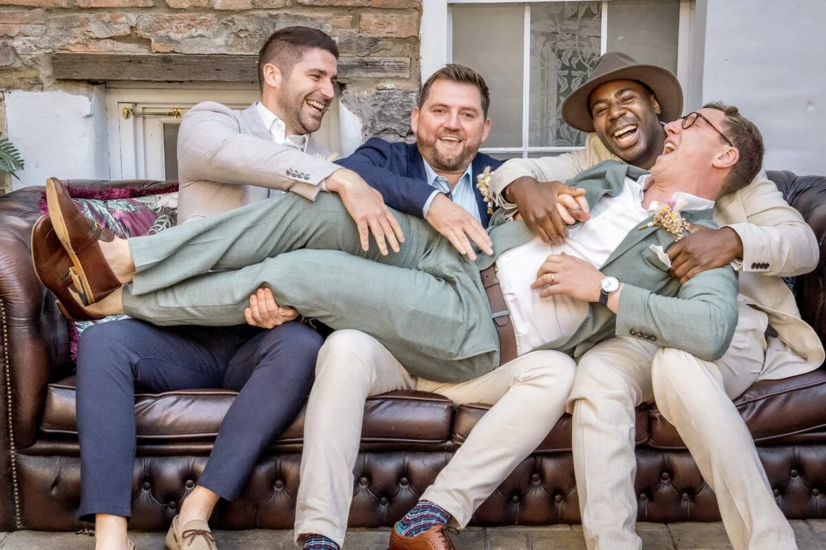A group of men sitting on a leather couch.