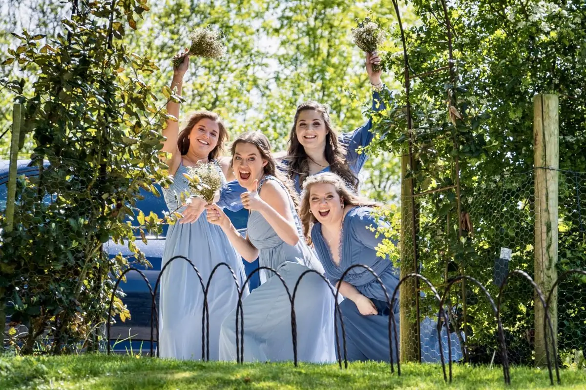 A group of bridesmaids posing for a photo in a garden.