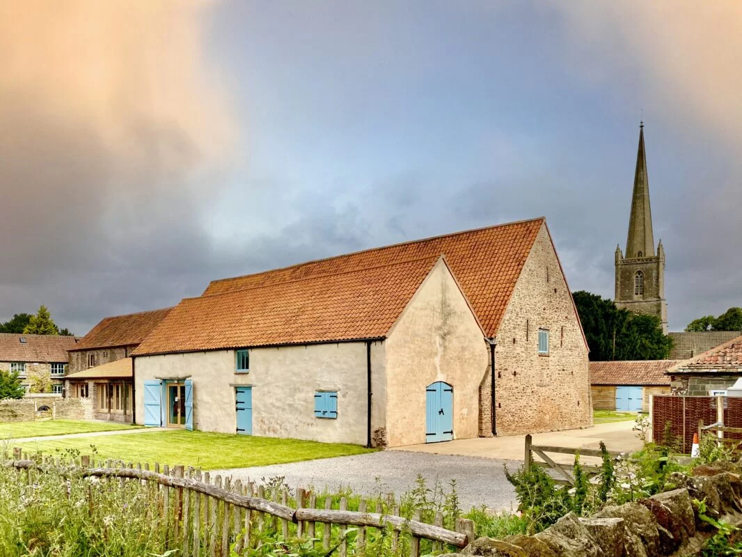 An old building with blue shutters and a spire.