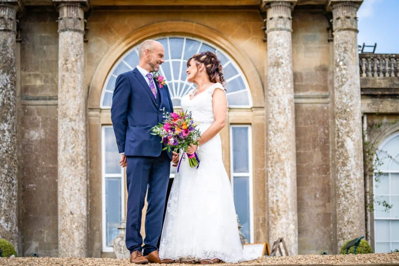 The best wedding photographer capturing a bride and groom in front of an ornate building in Bristol.