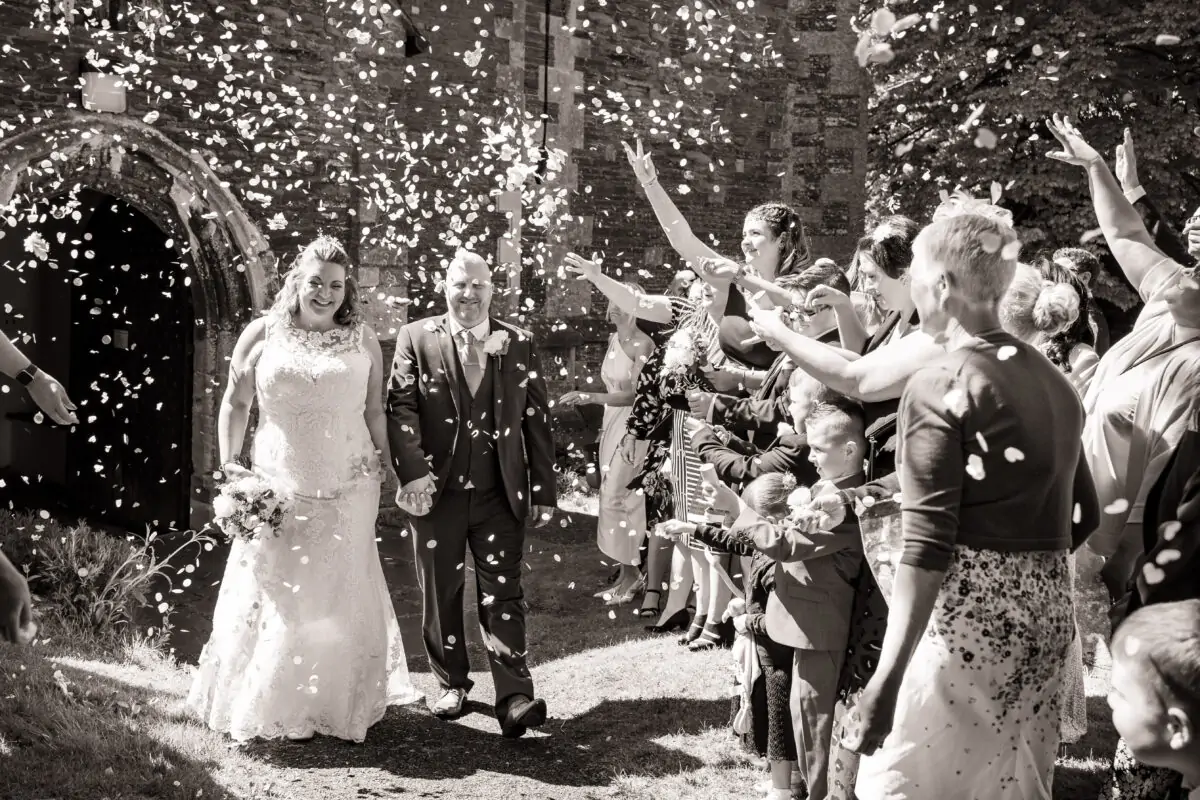 A bride and groom are being confettied by confetti.