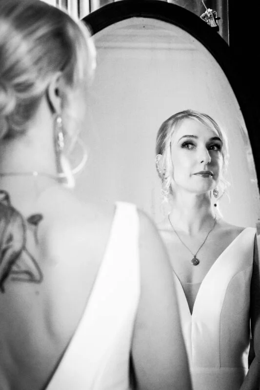 A bride looking at herself in a mirror.