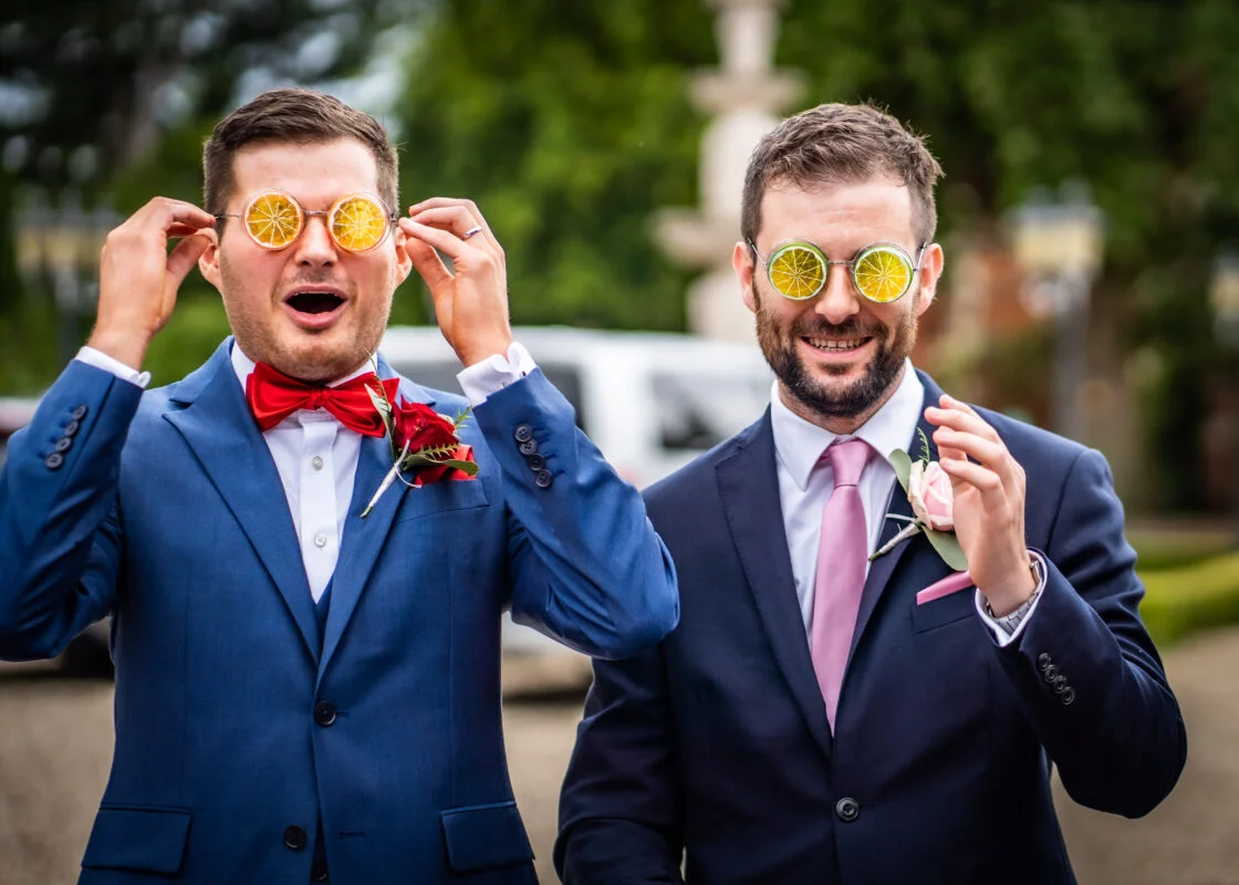 Two men in suits with sunglasses on their faces.