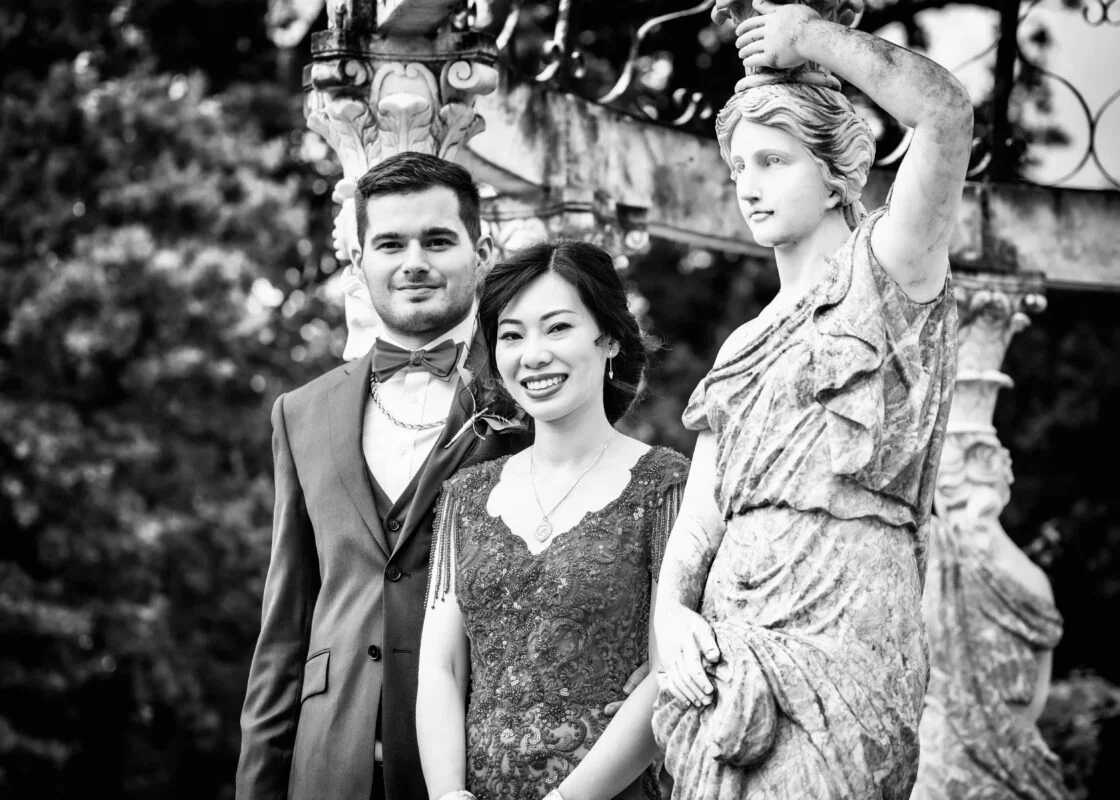 A black and white photo of a man and woman standing next to a statue.