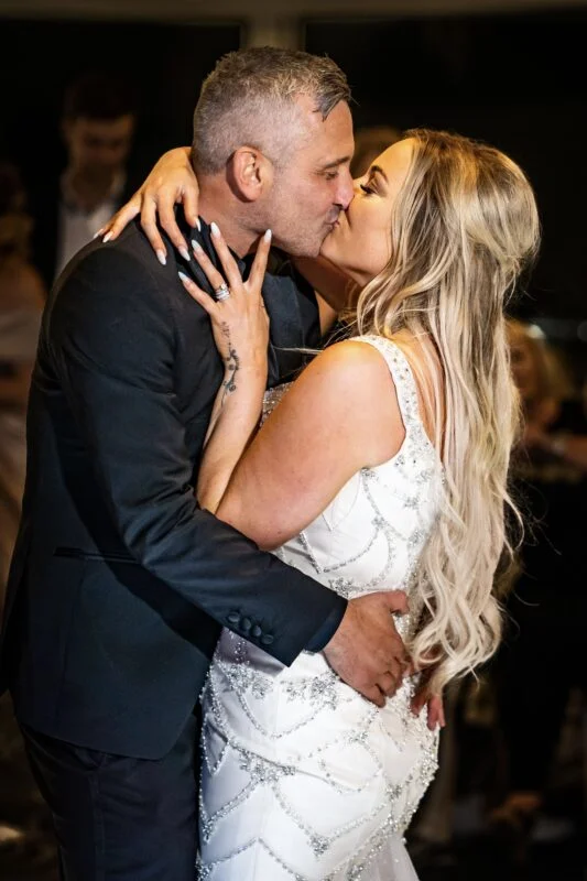 A bride and groom kiss during their first dance.