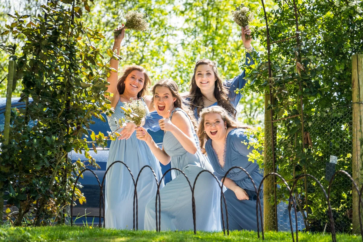 A group of bridesmaids posing for a photo in a garden.