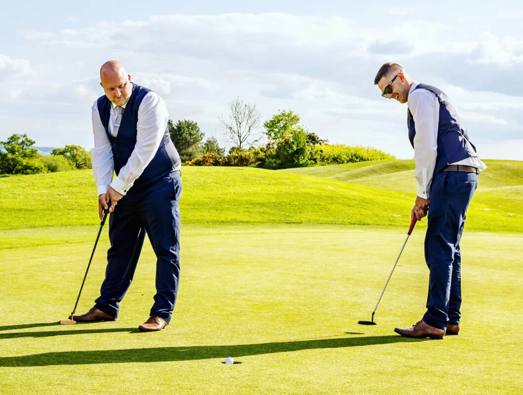 Two men playing golf on a golf course.