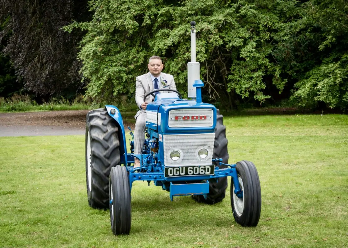 A blue tractor with a man on it.