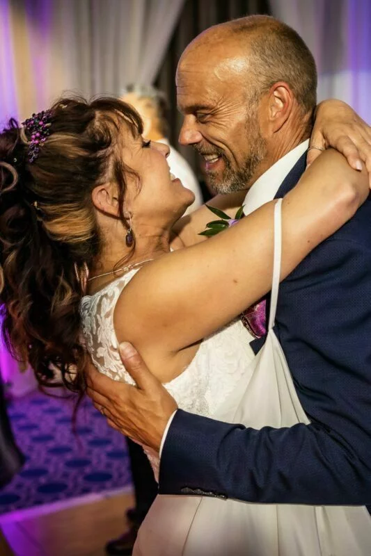 A bride and groom hugging during their first dance.