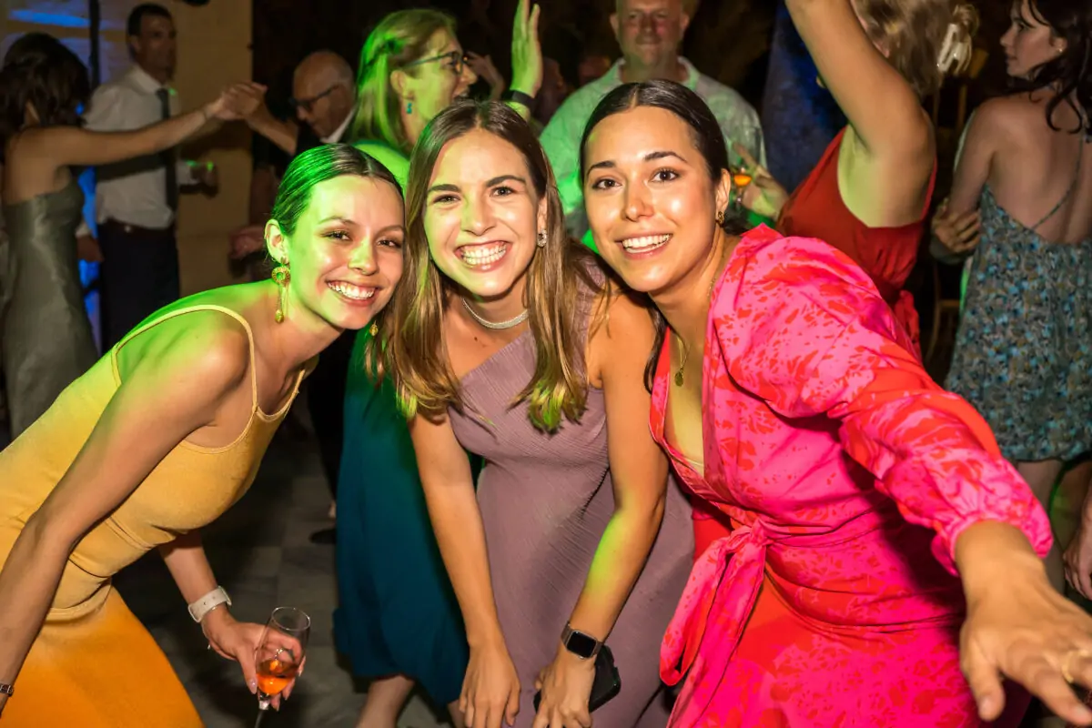 Three women posing for a photo at a party.