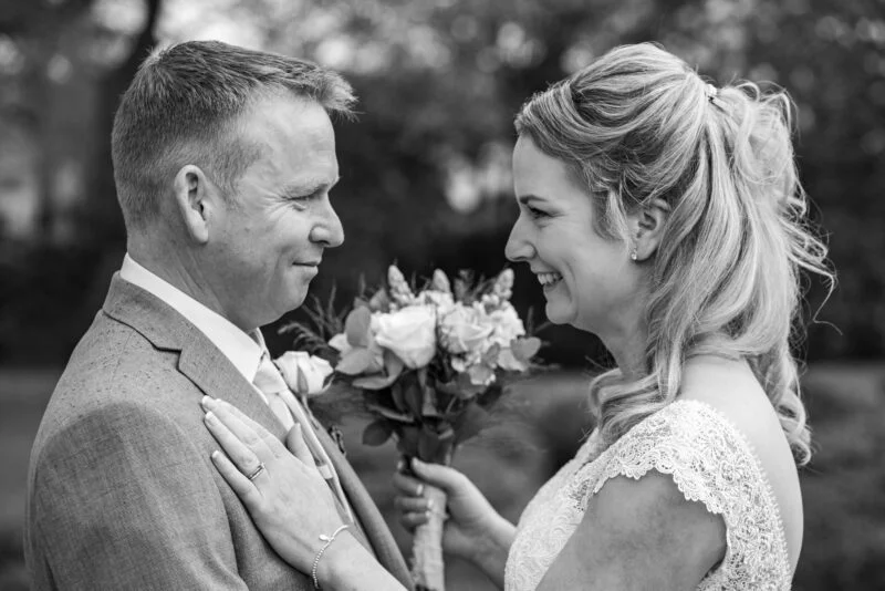 A black and white photo of a bride and groom looking at each other.