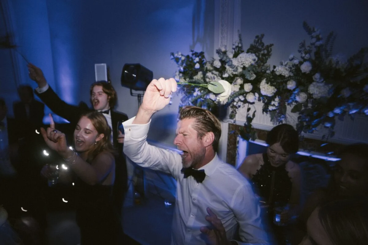 A man in a tuxedo is holding a sparkler.