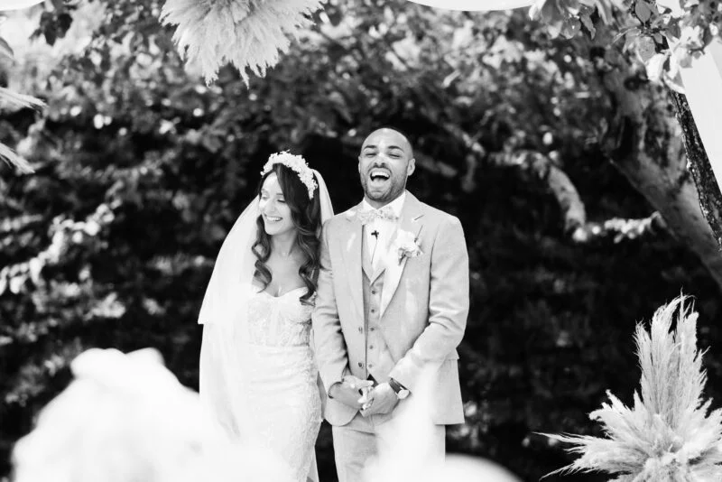 Black and white photo of a bride and groom at their wedding ceremony.