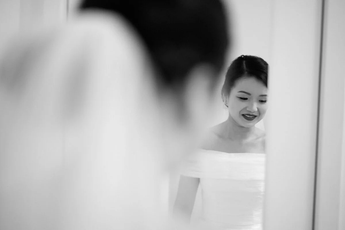 A bride looking at herself in a mirror.