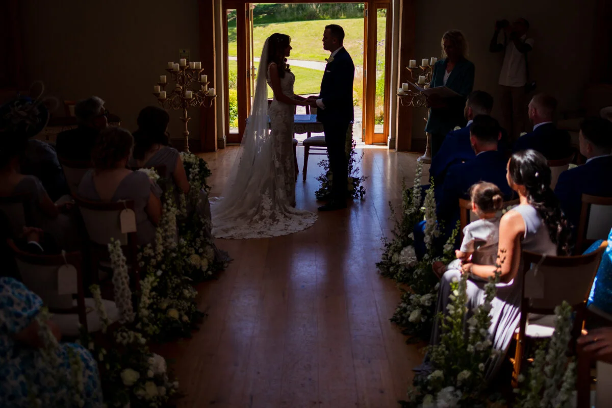A bride and groom standing in an open doorway during their wedding ceremony.