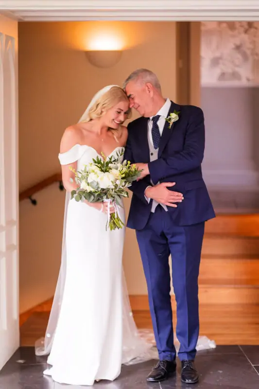 A bride and groom standing in front of a doorway.