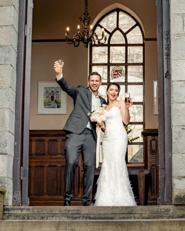 A bride and groom standing on the steps of a church.