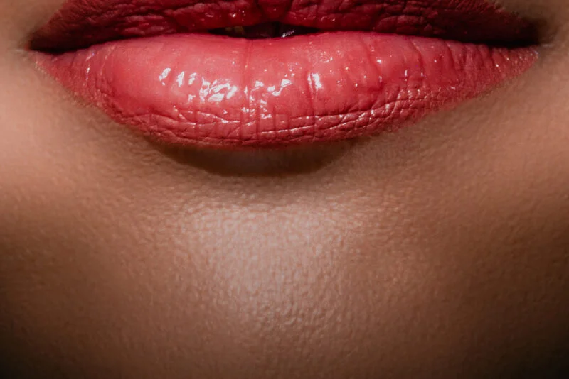 A close up of a woman's lips with red lipstick.