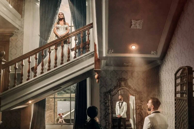 A bride and groom standing in front of a staircase.