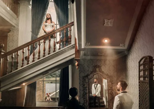 A bride and groom standing in front of a staircase.