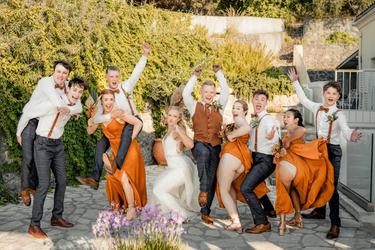 A group of bridesmaids and groomsmen posing for a photo.