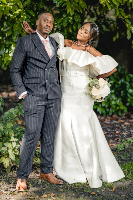 A bride and groom posing for a photo in the woods.