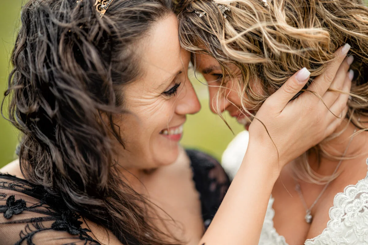 Two women hugging each other in a field.